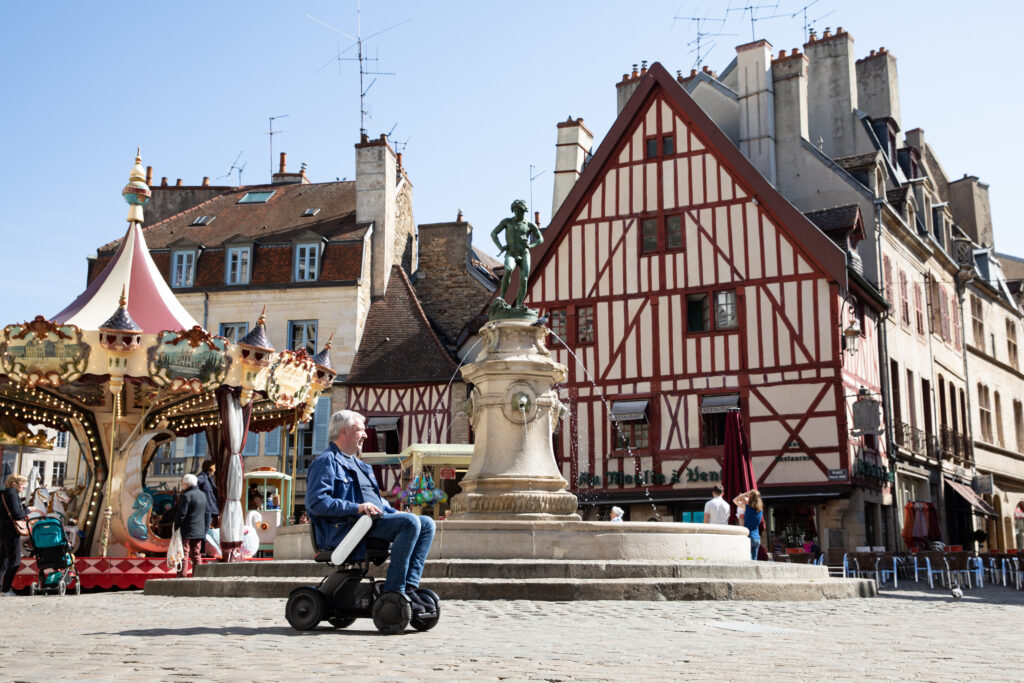 Personne en fauteuil roulant sur la place Darcy